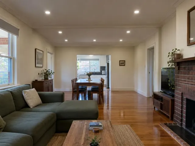 Living room with recessed ceiling downlights, timber floors and brick fireplace in Mayfield